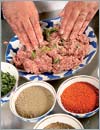 Пропустить куски мяса через мясорубку или измельчить блендером. Вымесить фарш руками до однородного состояния.
