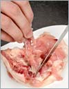 Сделать глубокий надрез вдоль бедренной кости и, аккуратно подрезая мясо, удалить кость.