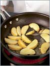 В другой сковороде разогреть оставшееся растительное масло, небольшими порциями обжаривать яблоки и картофель до образования золотистой корочки.