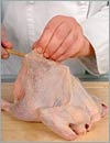 С помощью деревянной палочки с тупым концом отделить кожу от мяса цыплят.