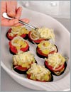 На каждый кружок баклажана положить кружок помидора, затем 1 ст. л. мармелада из цуккини с луком. Сверху присыпать тертым сыром. 