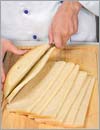 Нарезать хлеб длинными продольными пластинами толщиной 5 мм.